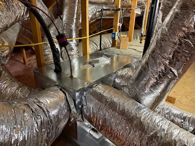 Insulated air conditioning ductwork and air handler in a residential attic