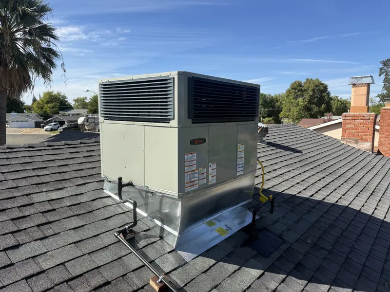New rooftop package HVAC unit installed level on a shingle roof